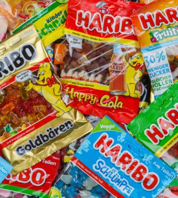 Photo shows a piled selection of famous Haribo sweet wrappers layered on top of one another.