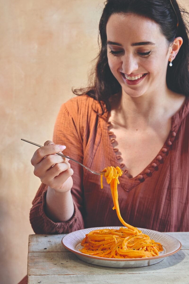 Vegan recipe developer Madeleine Olivia eating vegan high protein pepper pasta
