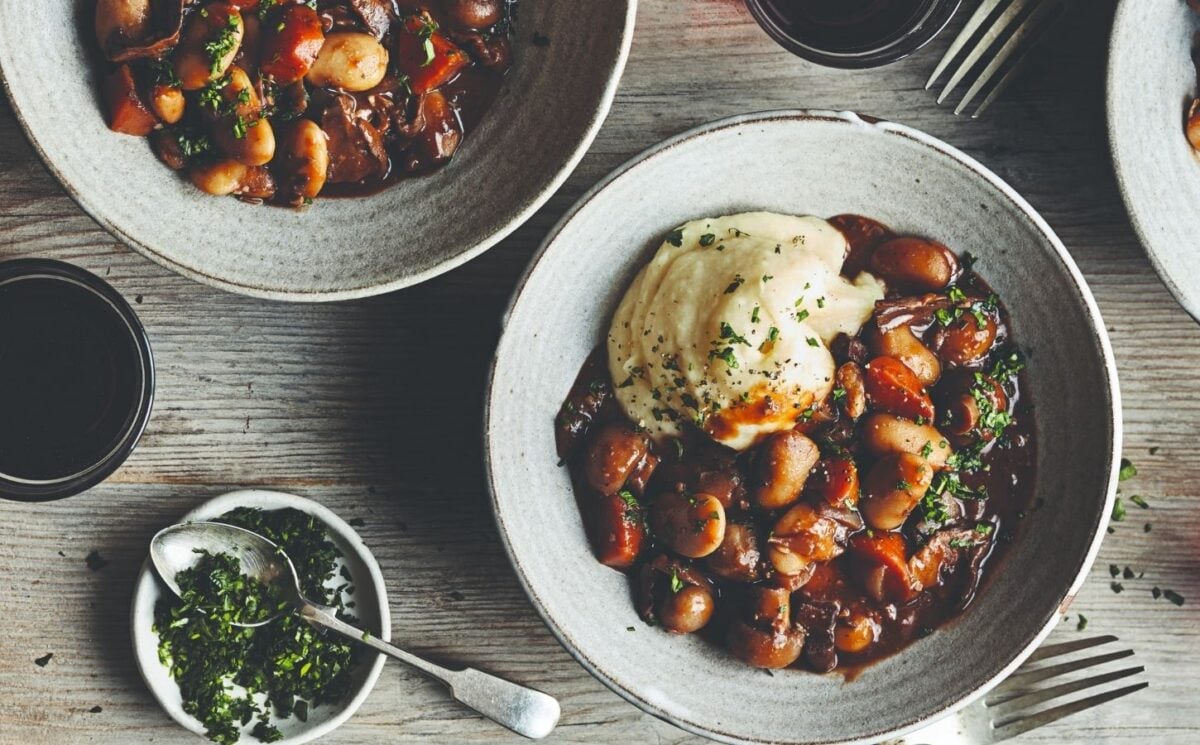Photo shows two dishes of vegan butter bean-based bourguignon.