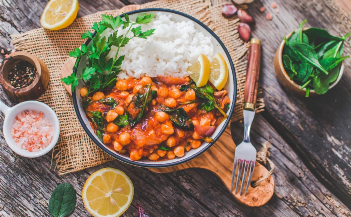 Photo shows a Mediterranean chickpea stew served over rice and topped with citrus and cilantro.