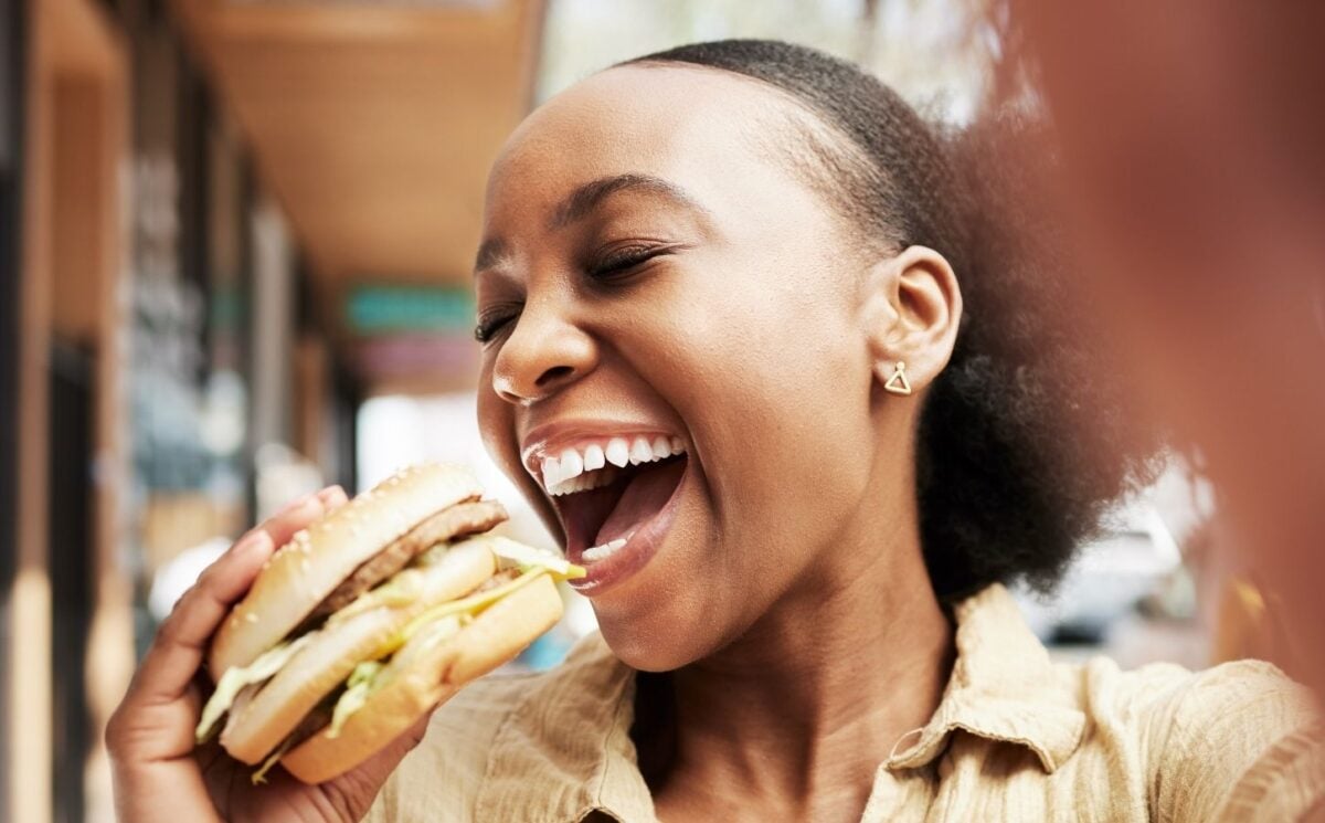Woman eating a burger in one of the top vegan cities
