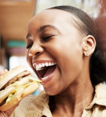 Woman eating a burger in one of the top vegan cities