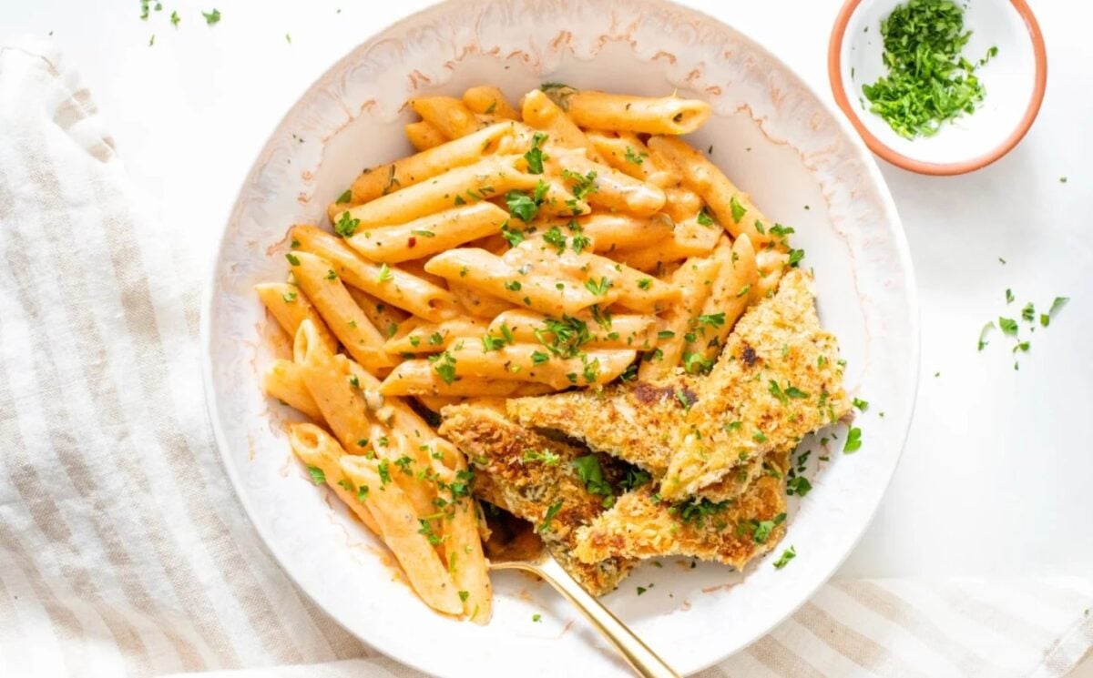 Photo shows a creamy Cajun pasta dish topped with tempeh.