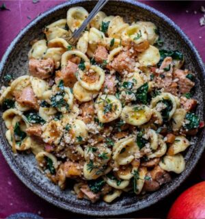 Photo shows a large bowl of sausage and kale pasta prepared using a vegan comfort food recipe.