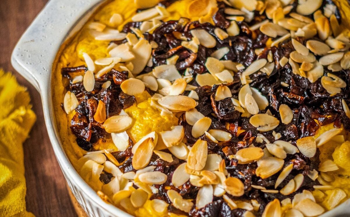 Photo shows a cauliflower bake topped with caramelized onions and almonds.