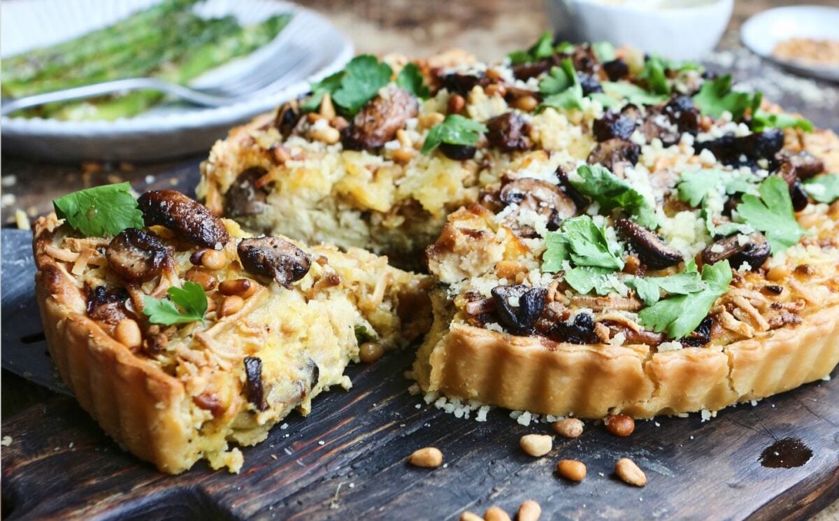 Photo shows a vegan blue cheese quiche with a slice cut to show the creamy filling.