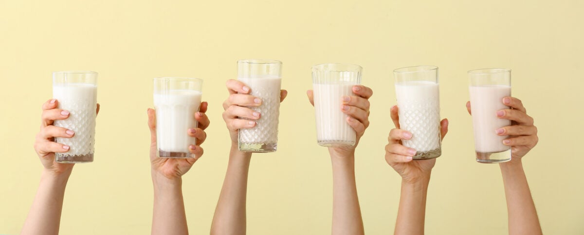 Hands holding plant-based milk in the air