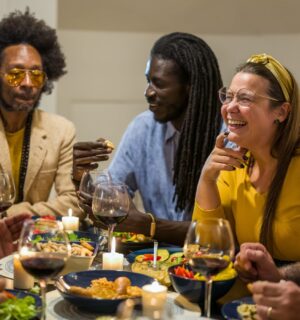 Happy vegans eating around a table celebrating Veganuary