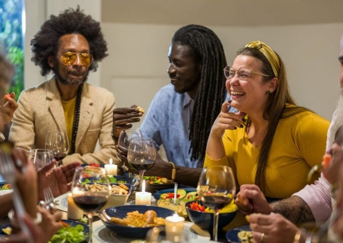 Happy vegans eating around a table celebrating Veganuary