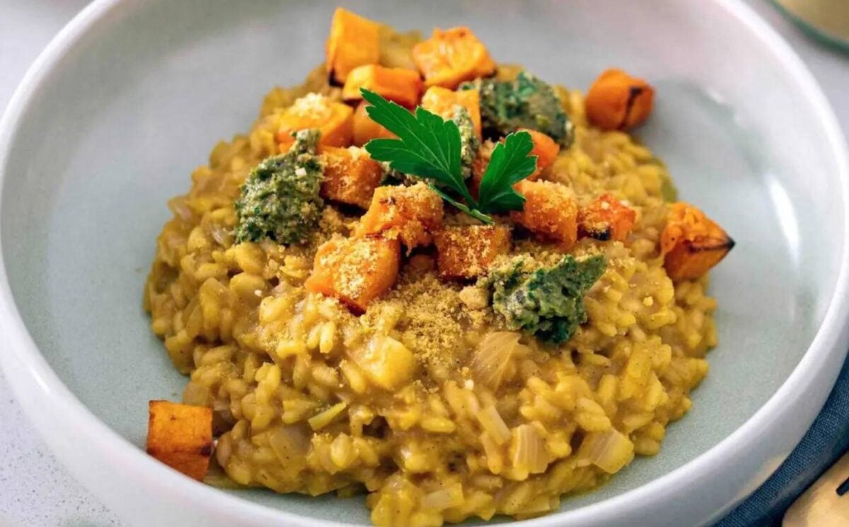 A bowl of vegan butternut squash risotto topped with roasted butternut squash cubes
