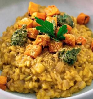 A bowl of vegan butternut squash risotto topped with roasted butternut squash cubes