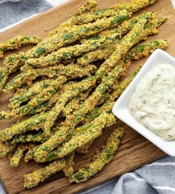 A chopping wooden board covered in oil-free green bean fries