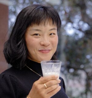 TurtleTree CEO and Co-Founder Fengru Lin holds a glass of the world's first vegan-certified lactoferrin, LF+