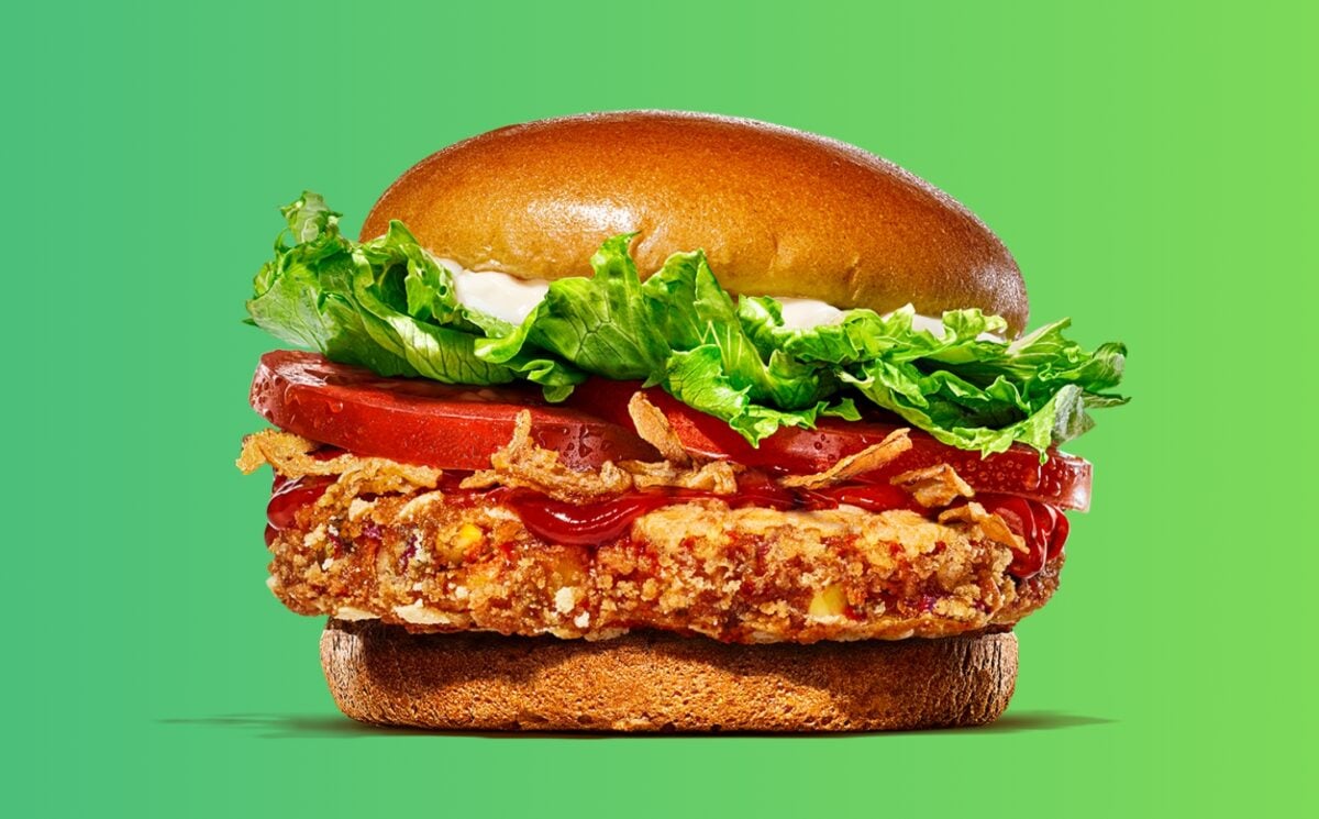 A plant-based Burger King bean burger in front of a green background 