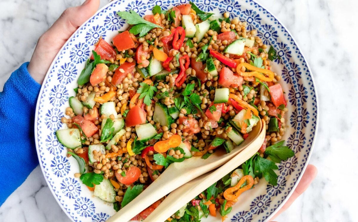 Photo shows a colorful lentil salad complete with fresh vegetables
