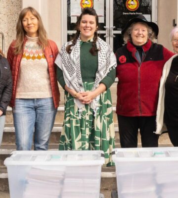 Photo shows five CEFF volunteers standing with large boxes of signatures before handing them in