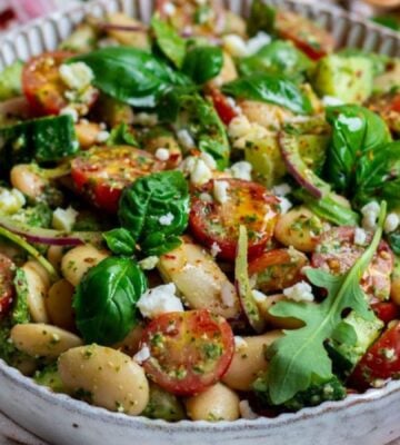 A butter beans salad recipe featuring tomatoes, spinach, and vegan cheese