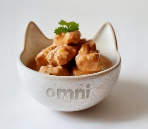 A bowl of cat food made from cultivated chicken in a bowl reading "omni"