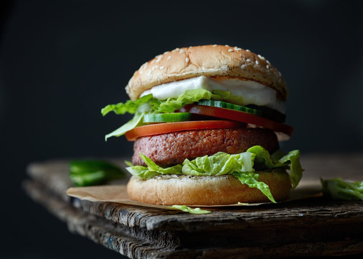 Photo shows a tall burger made using Impossible's plant-based patty.
