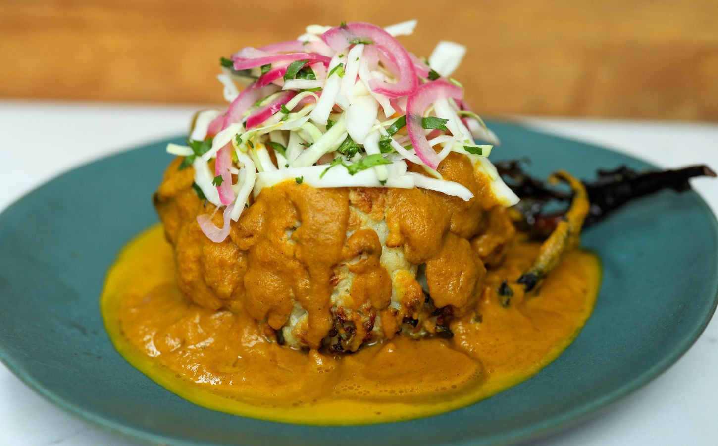 roasted cauliflower in a creamy katsu curry sauce topped with pickled onion and cabbage salad