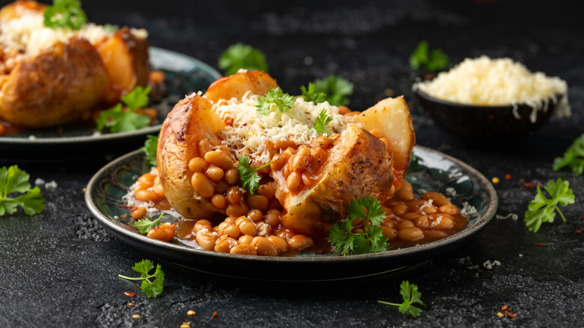 Photo shows a baked or "jacket" potato topped with baked beans and grated cheese