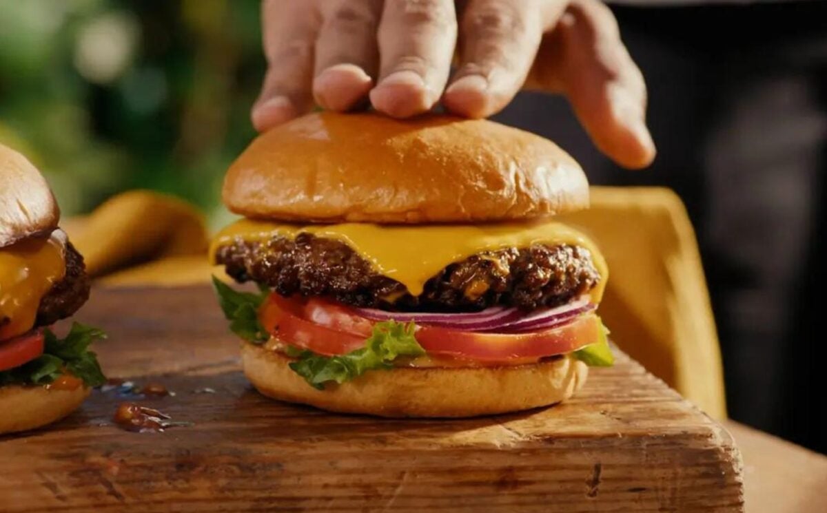 A still from dairy-free company Daiya's advert featuring a real beef burger with vegan cheese