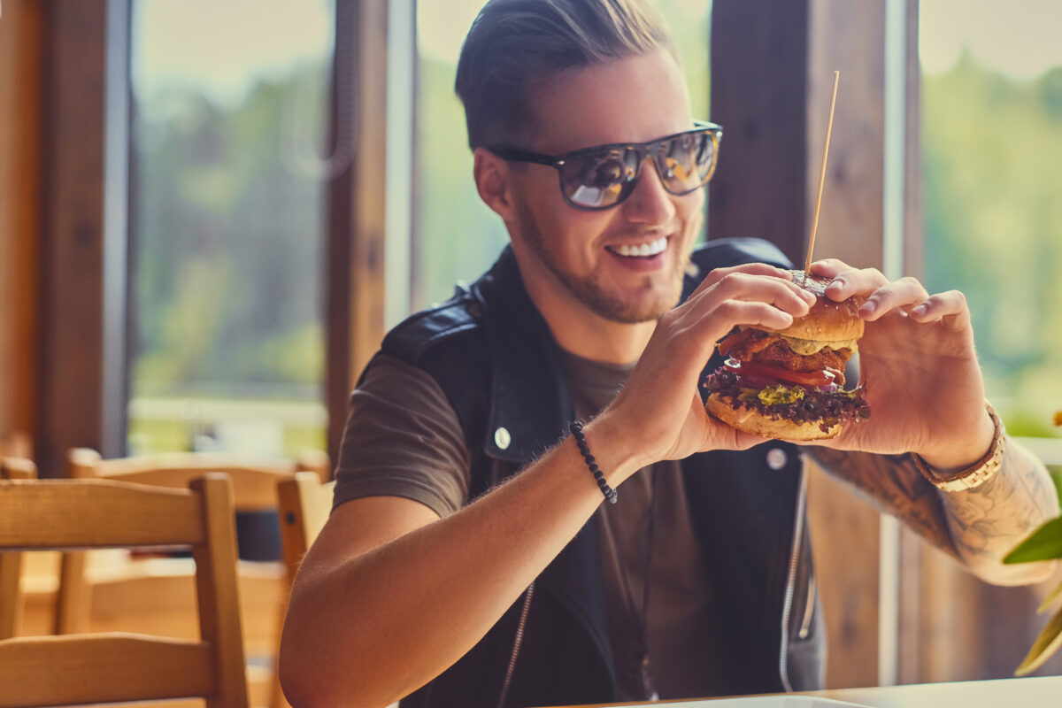A man eating a realistic vegan burger