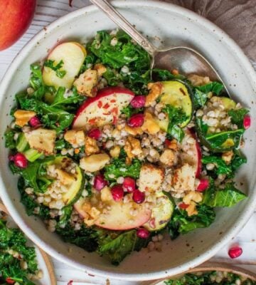 Photo shows Happy Skin Kitchen's kale and apple salad in a large pale bowl alongside smaller bowls with the component ingredients in