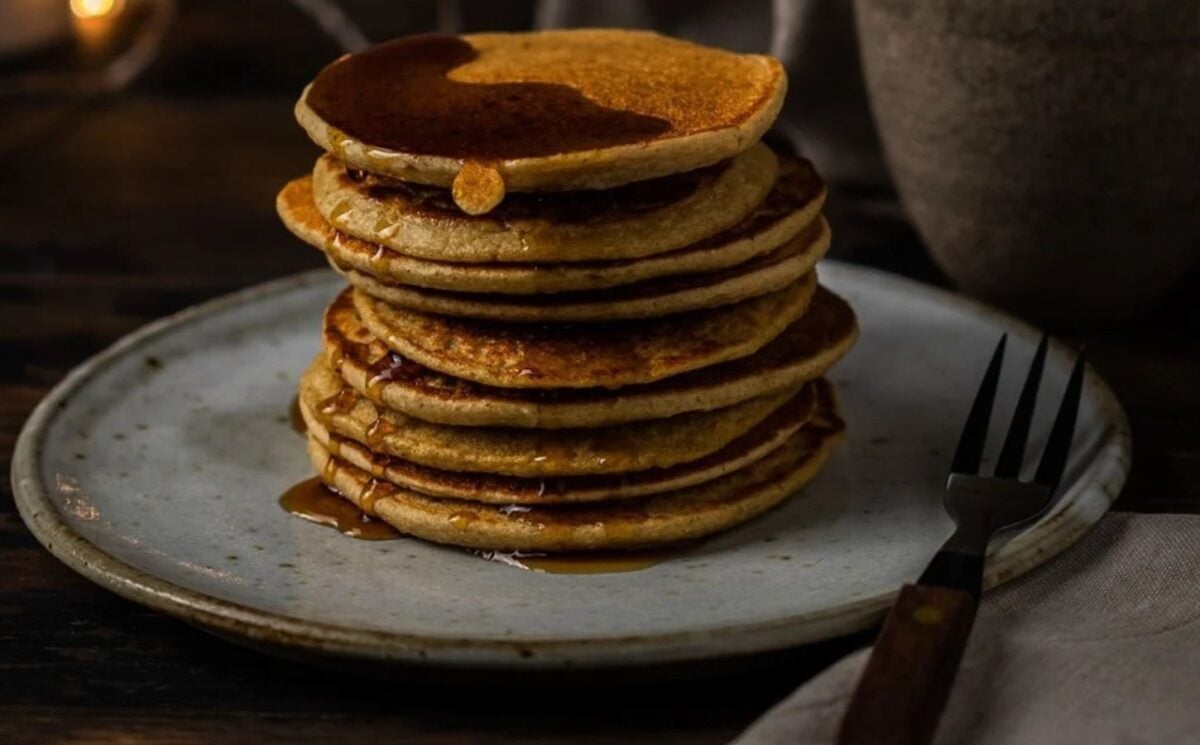 Photo shows a tall stack of banana oat pancakes prepared to a vegan recipe
