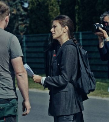 A still from new vegan documentary Food For Proft, showing a woman interviewing a man while another man holds a camera