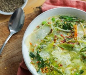 vegan green minestrone soup with pistachio pesto and vegetables