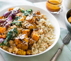 vegan roasted butternut squash and quinoa bowl made with chickpeas spinach and an almond citrus sauce