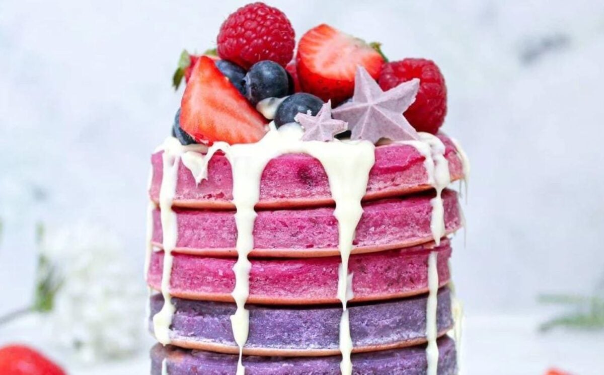 Photo shows a stack of brightly colored "unicorn" pancakes prepared to a vegan recipe