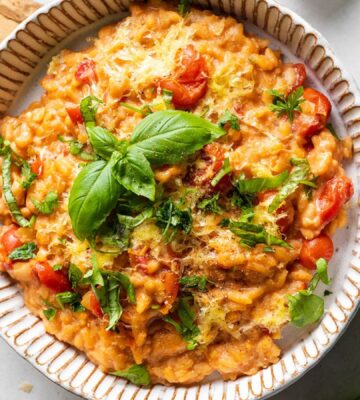 A bowl of vegan cherry tomato risotto made to a dairy-free and plant-based recipe