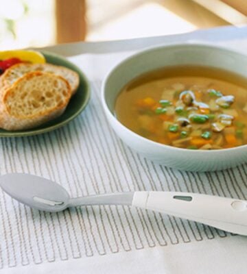 Photo shows the new Electric Salt Spoon next to a bowl of miso and a bread-based side on a white patterned table