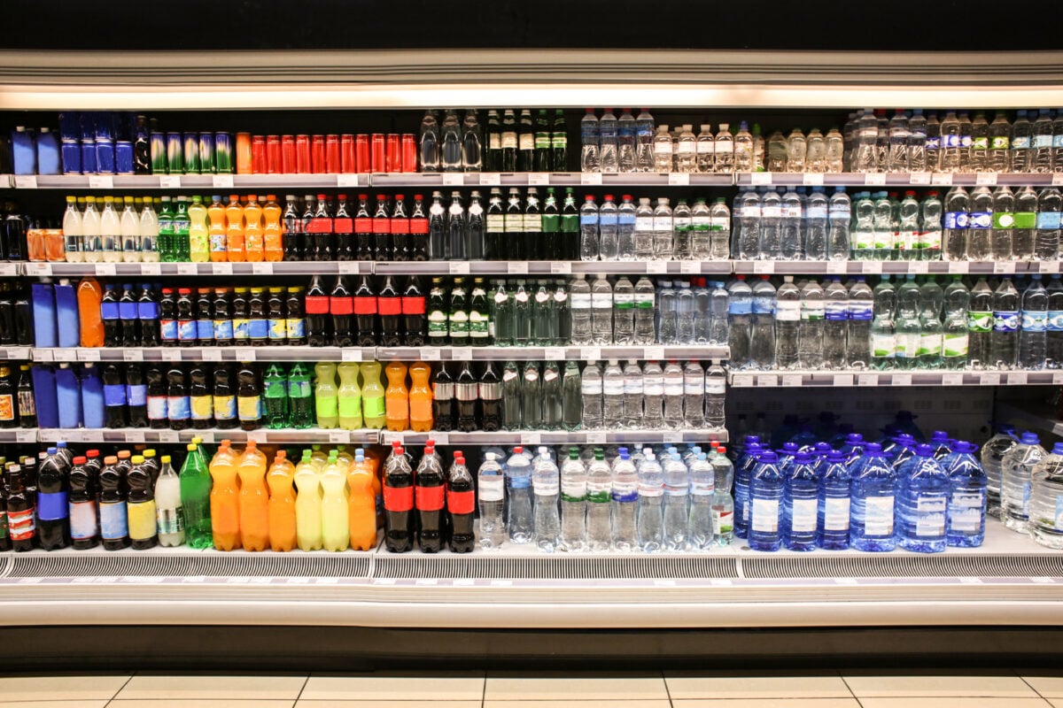 Photo shows various different soft drinks and waters in bottles on a supermarket's shelves