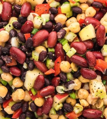 three bean salad made with chickpeas, kidney beans, black beans, apple pieces, and a tangy vinegar dressing