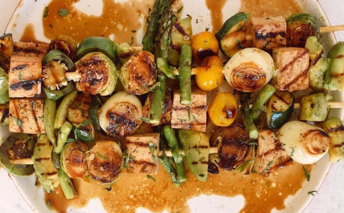 Photo shows a plate of tofu, avocado, and vegetable kebabs