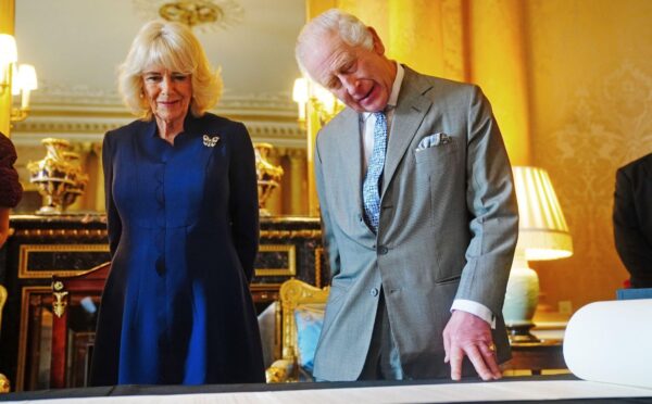 King Charles and Queen Camilla look at the Coronation Roll