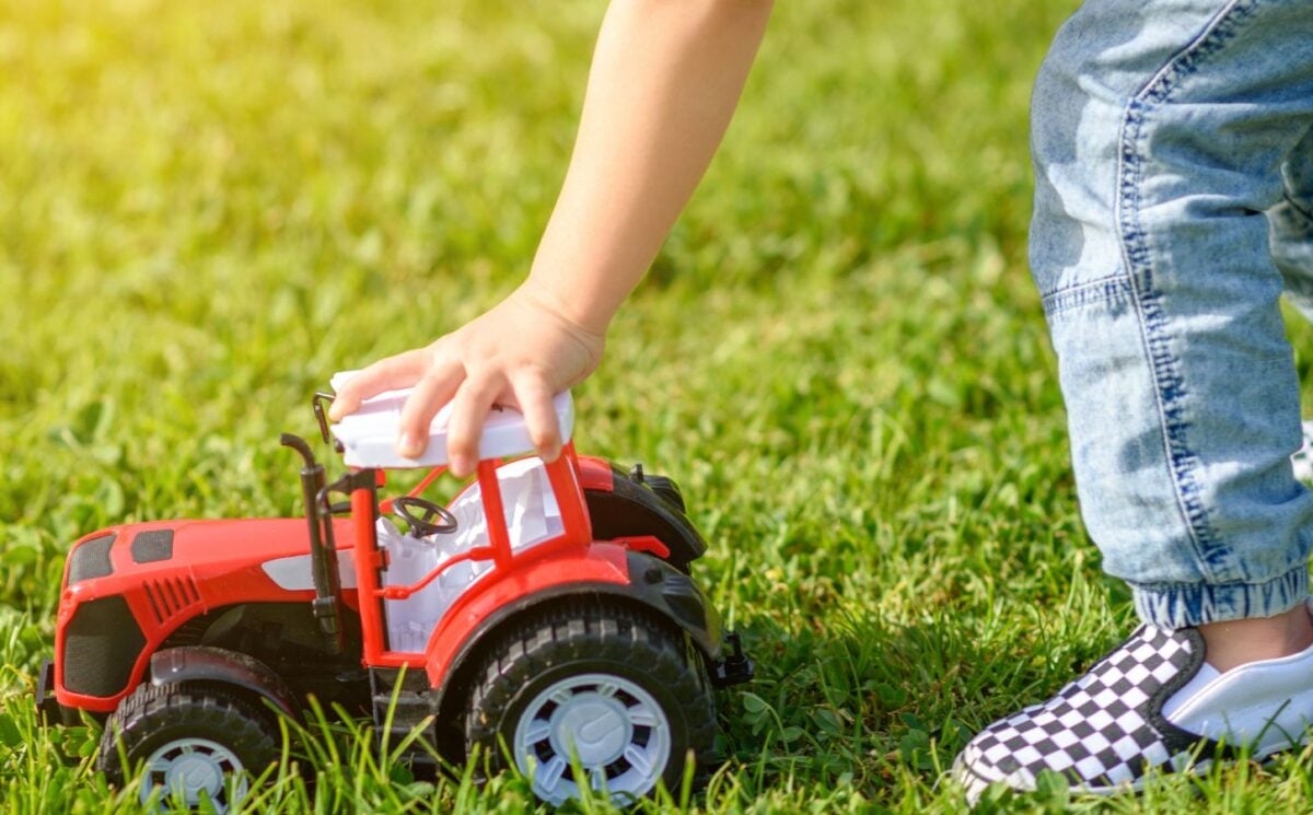 A child playing with a red toy car made from brightly colored plastic, which experts are urging retailers to move away from over microplastics fears