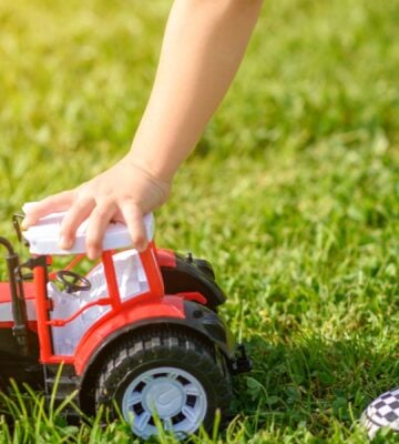 A child playing with a red toy car made from brightly colored plastic, which experts are urging retailers to move away from over microplastics fears