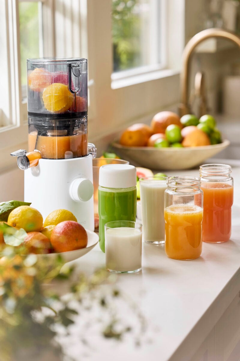 A close up of a compact Nama J3 juicer with fruit in it