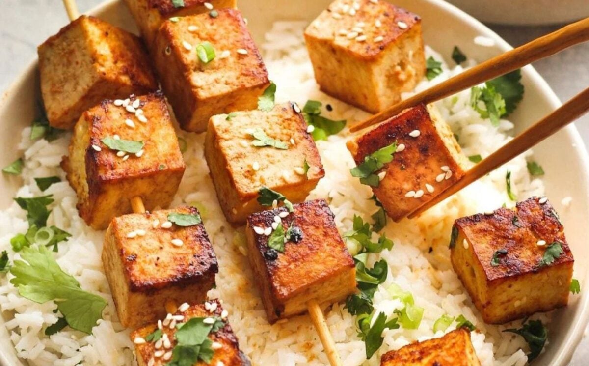 Photo shows a bowl of tofu skewers served over rice
