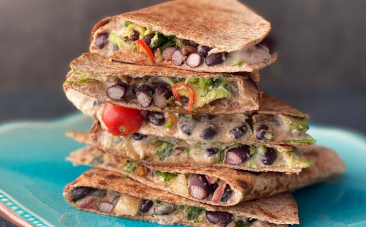 Photo shows a stack of vegan quesadillas made with black beans
