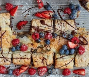 Photo shows a large croissant and chocolate "tearer sharer" made using fresh berries, puff pastry, and chocolate - prepared to a vegan recipe