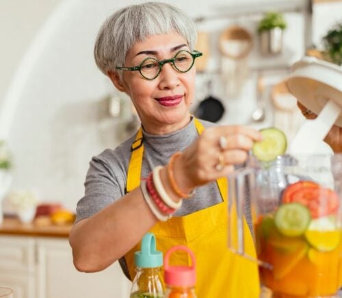 A woman cooking healthy plant-based food in a food processor