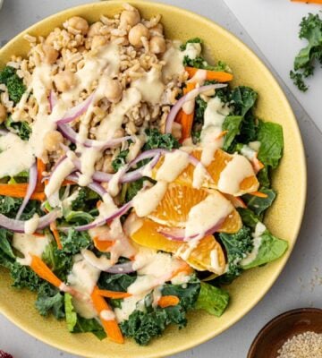 A bowl of vegan kale salad made with orange sesame dressing