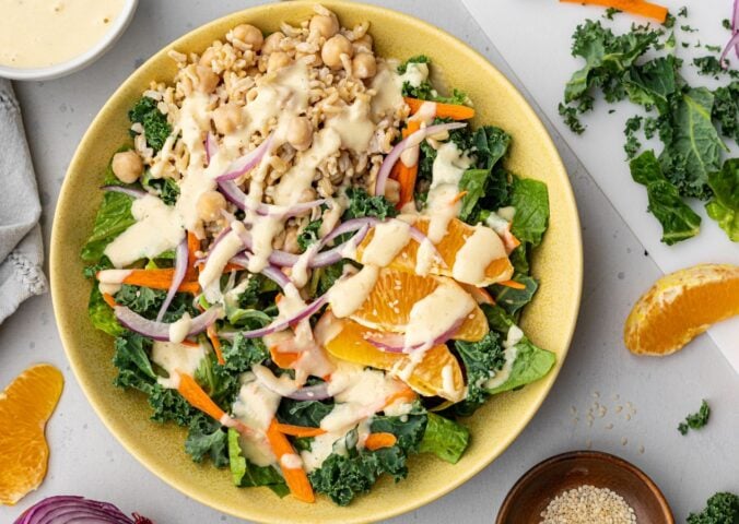 A bowl of vegan kale salad made with orange sesame dressing