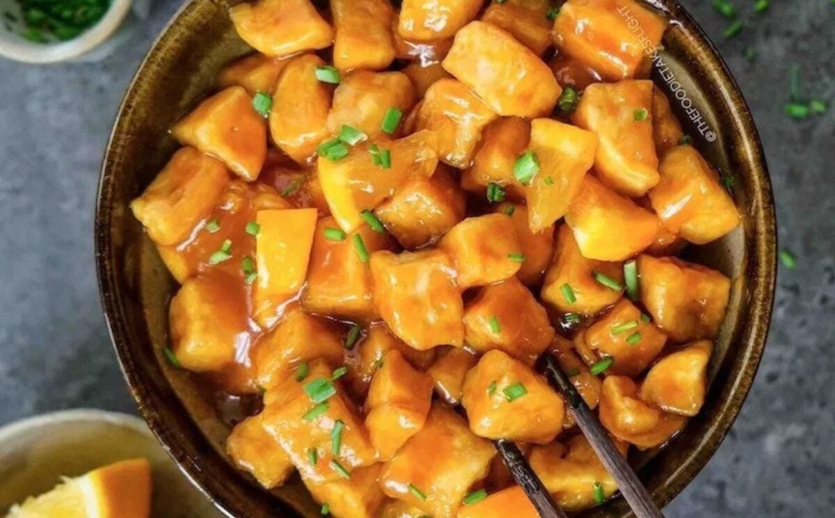 Photo shows a large bowl full to the brim of orange tofu over a bed of rice
