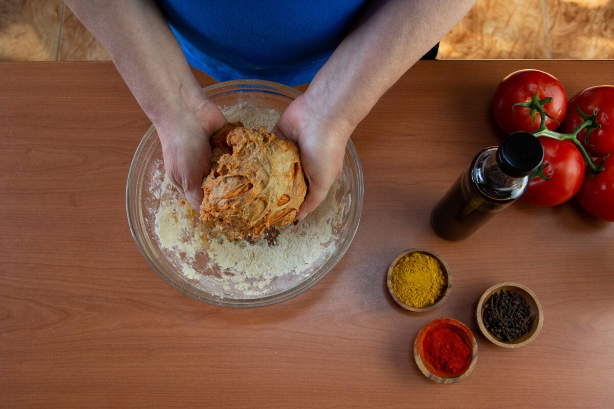 Photo shows someone's hands as they knead a ball of vital wheat gluten dough